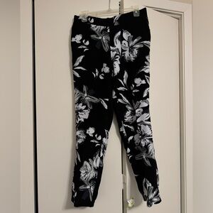 White floral print on black comfy pants. Creased front, elastic back cuff.